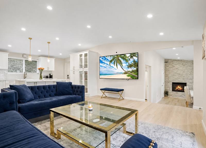 Open-plan luxury living room with blue velvet sofas and fireplace